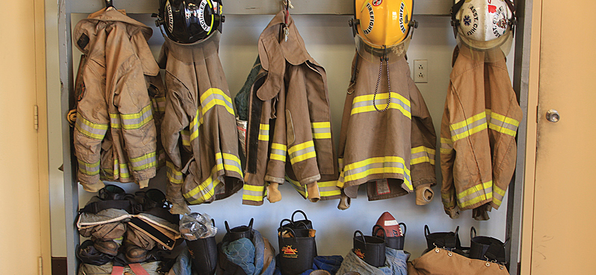 Firefighter gear hanging on fire hall wall